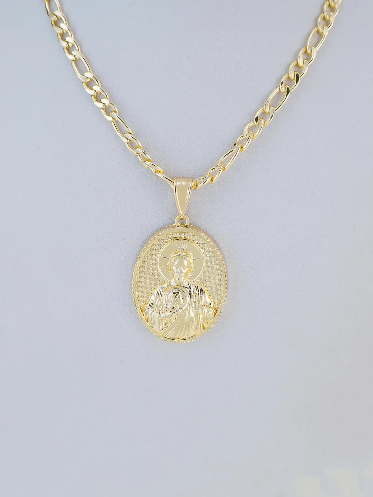 A gold-plated pendant necklace featuring a depiction of the Virgin Mary Christ.