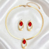Gold necklace set featuring a thin chain and three oval red gemstone pendant earrings