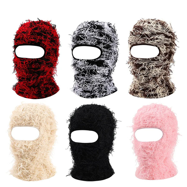 A collection of five distressed camouflage knit balaclava beanie hats in red, black, brown, beige, and pink.