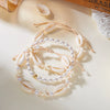 A delicate beaded anklet featuring starfish and pearl accents for summer beach wear.