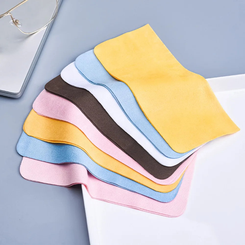 Una pila de paños de limpieza de ante multicolores en amarillo, rosa, azul y marrón sobre una superficie blanca.