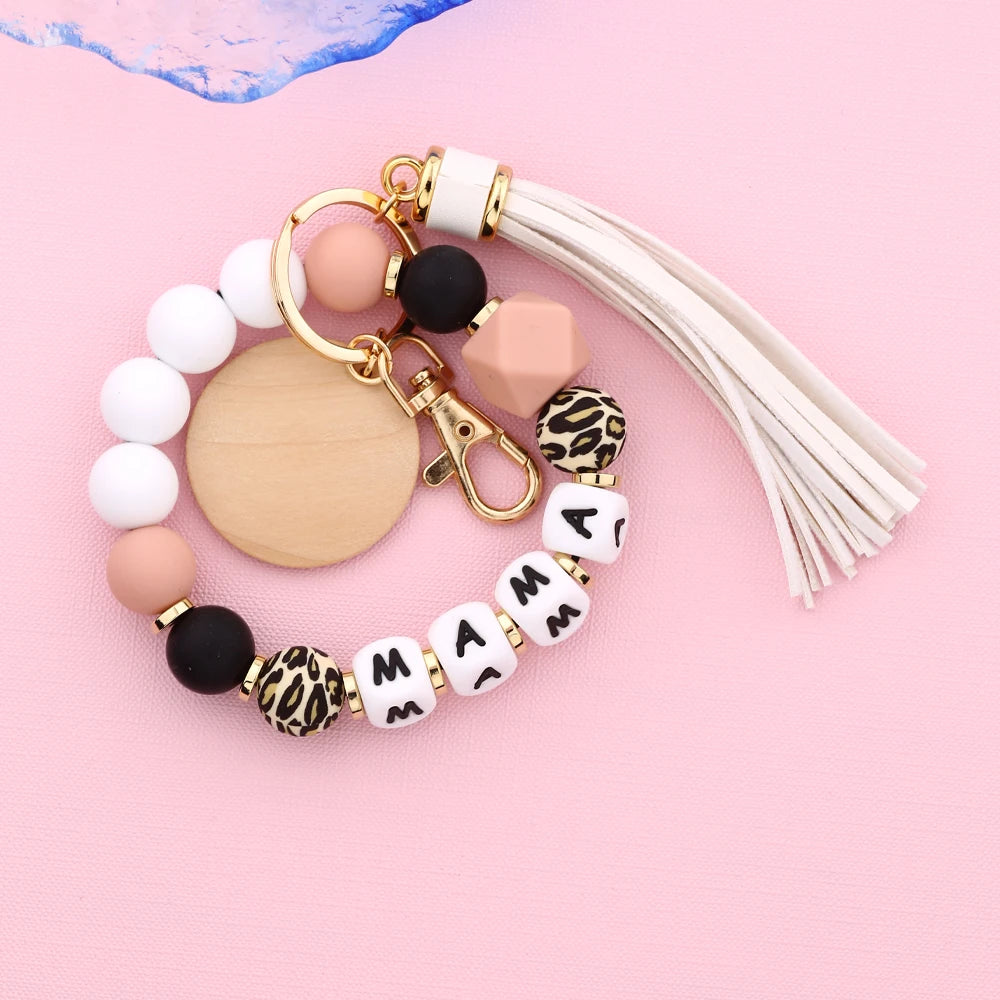 A leopard print silicone bead key chain featuring white, black, and nude colored beads on a gold-toned chain.