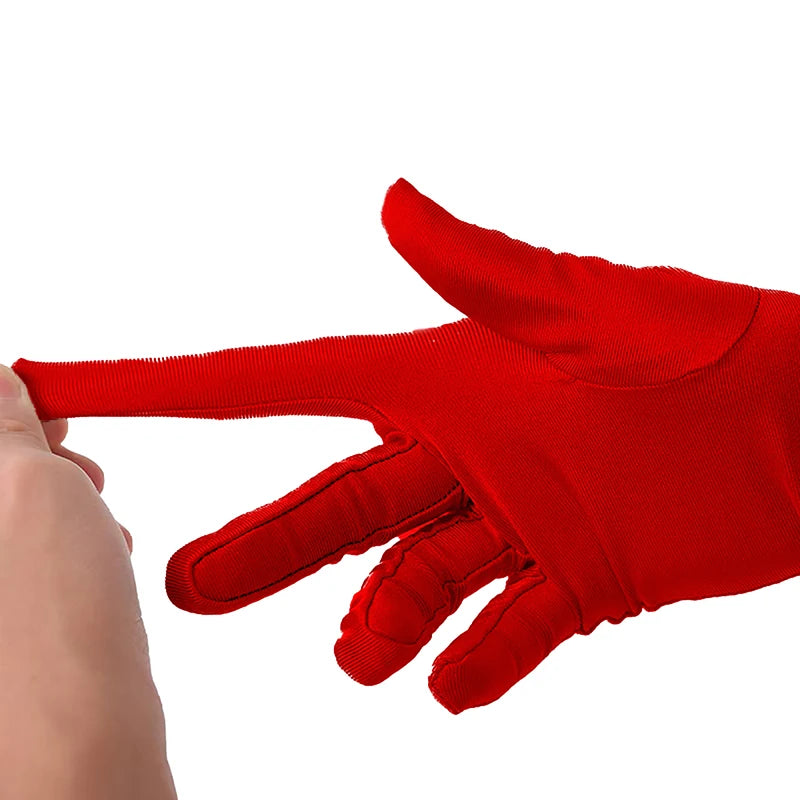 Eine Hand trägt ein leuchtend rotes Fingerschuh in Opernstil.
