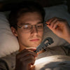 A person holds a precision eyeglass temple adjustment tool near their glasses.