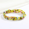 Una pila de collares hechos a mano con cuentas de colores: amarillo, rosa y turquesa.