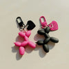 A pair of pink and black jelly cartoon dog keychains with attached split rings.