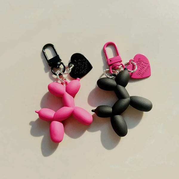 A pair of pink and black jelly cartoon dog keychains with attached split rings.