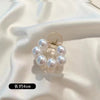 A set of simulated pearl hair claws with a silver finding and a 4cm length shown against a white satin background.
