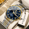 A close-up of a gold and silver watch with a blue dial and leather strap resting on a light background.