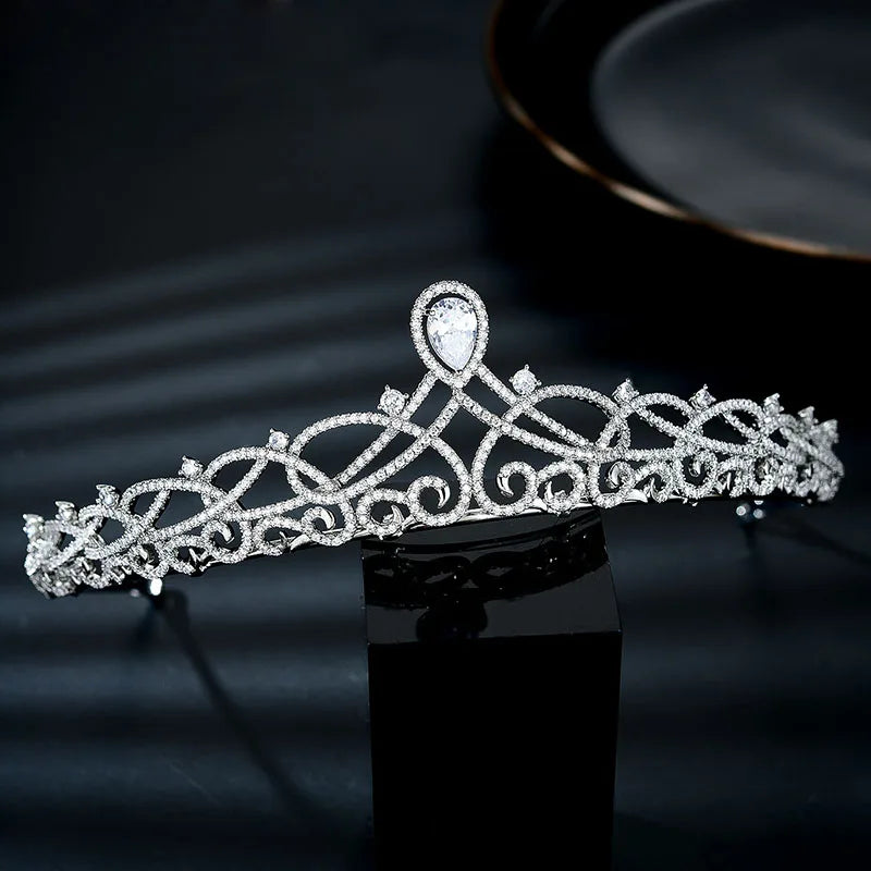 A sparkling cubic zirconia bridal tiara headband displayed on a black surface.