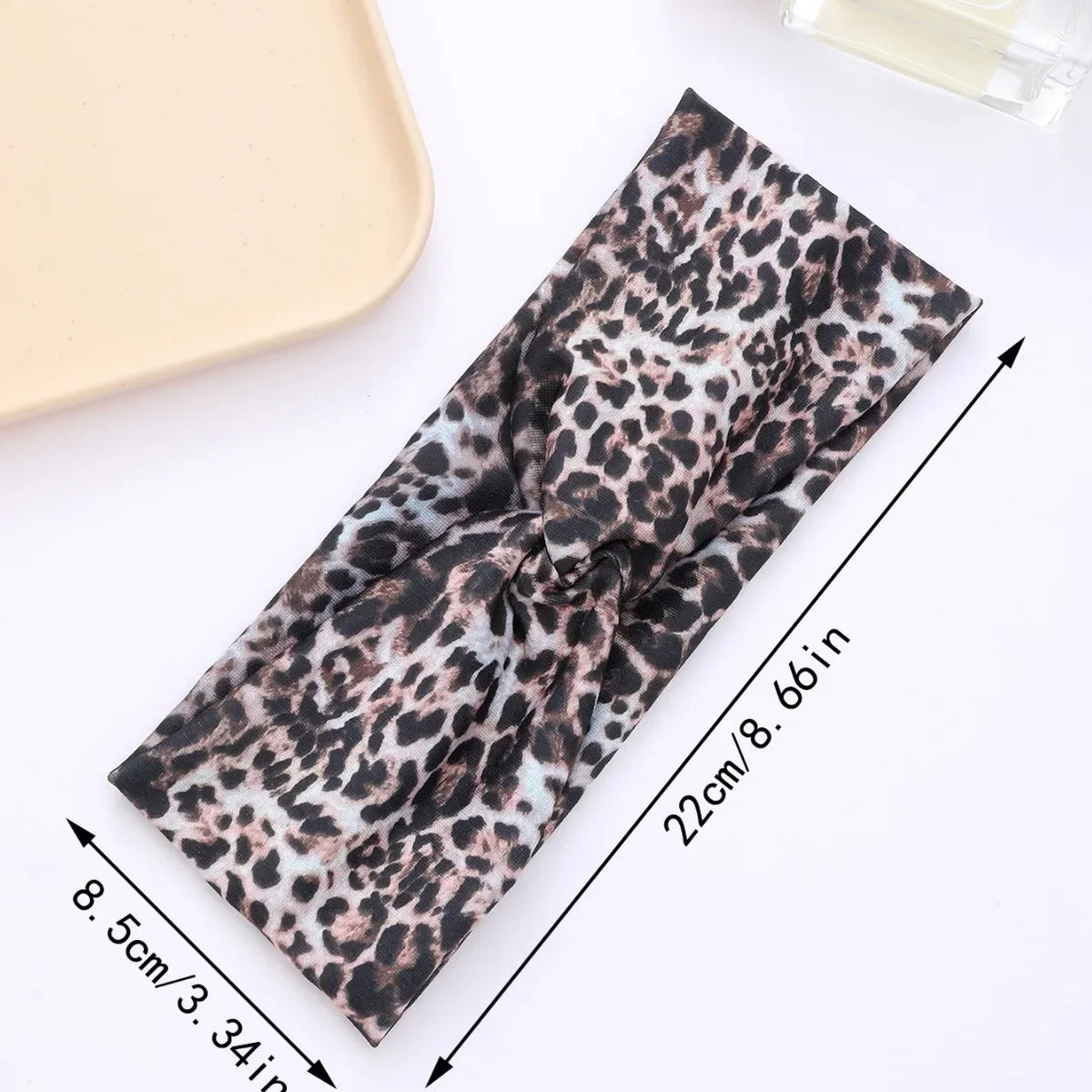 A black leopard print fabric headband shown flat with measurements.