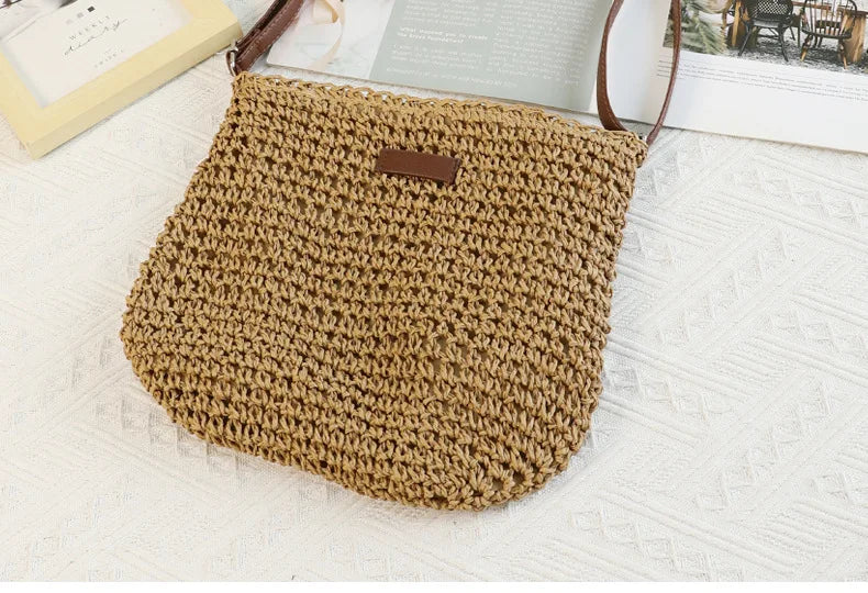 A hand-woven straw visor hat in a natural beige color resting on a white textured surface.