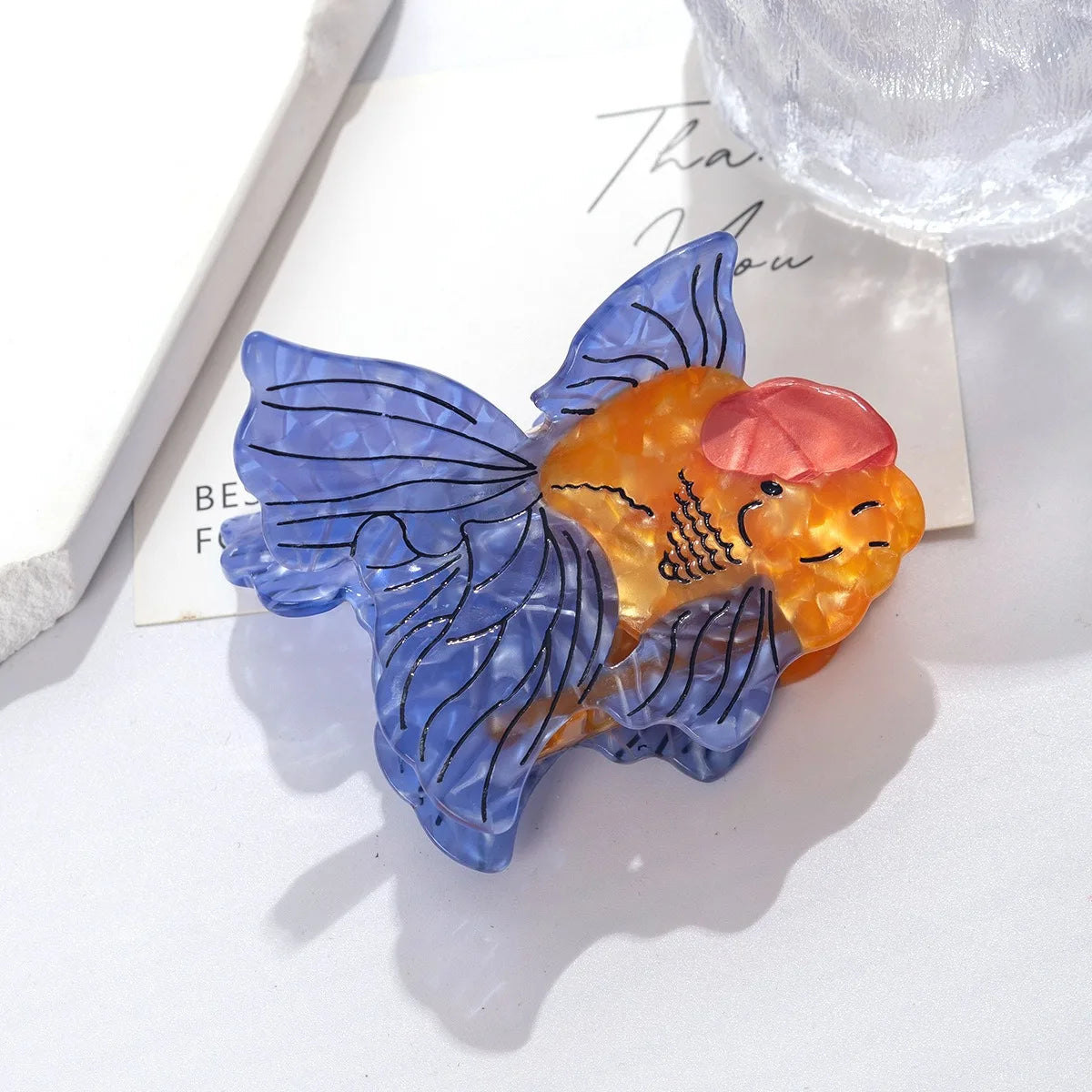 Un set de pinzas para el cabello con forma de animales y colores azul y naranja translúcidos.