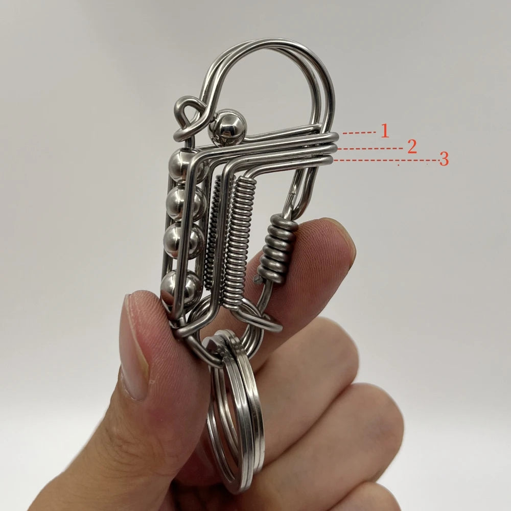 Un porte-clés mécanique en acier inoxydable avec mécanisme à ressort tenu dans la main d'une personne.