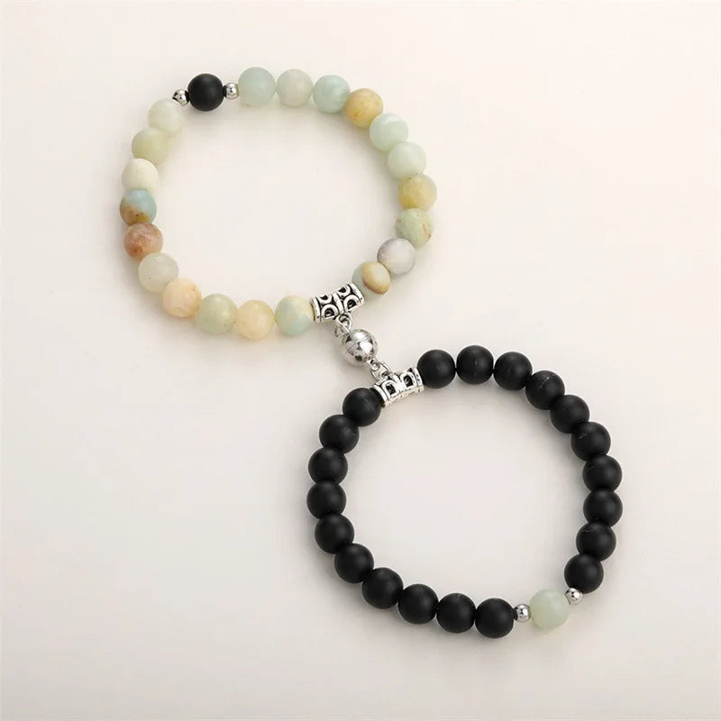 A set of natural stone heart couple bracelets featuring light green and black beads.