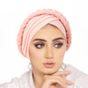 امرأة ترتدي غطاء رأس وردي ثلاثي مع ظلال عيون بنفسجية.