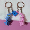 A set of couple shark keychain charms shaped like heart-shaped building blocks in blue and pink.