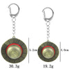 Silver metal keychain featuring a straw hat design with a circular detail and weight specifications.
