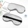 Silver silk sleep mask with a black strap shown next to a box labeled Chanel