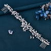 A delicate silver rhinestone bridal headband with floral and fringe details on a dark teal fabric.