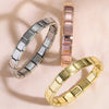Two stainless steel charm bracelets, one silver and one rose gold, displayed on a light background.