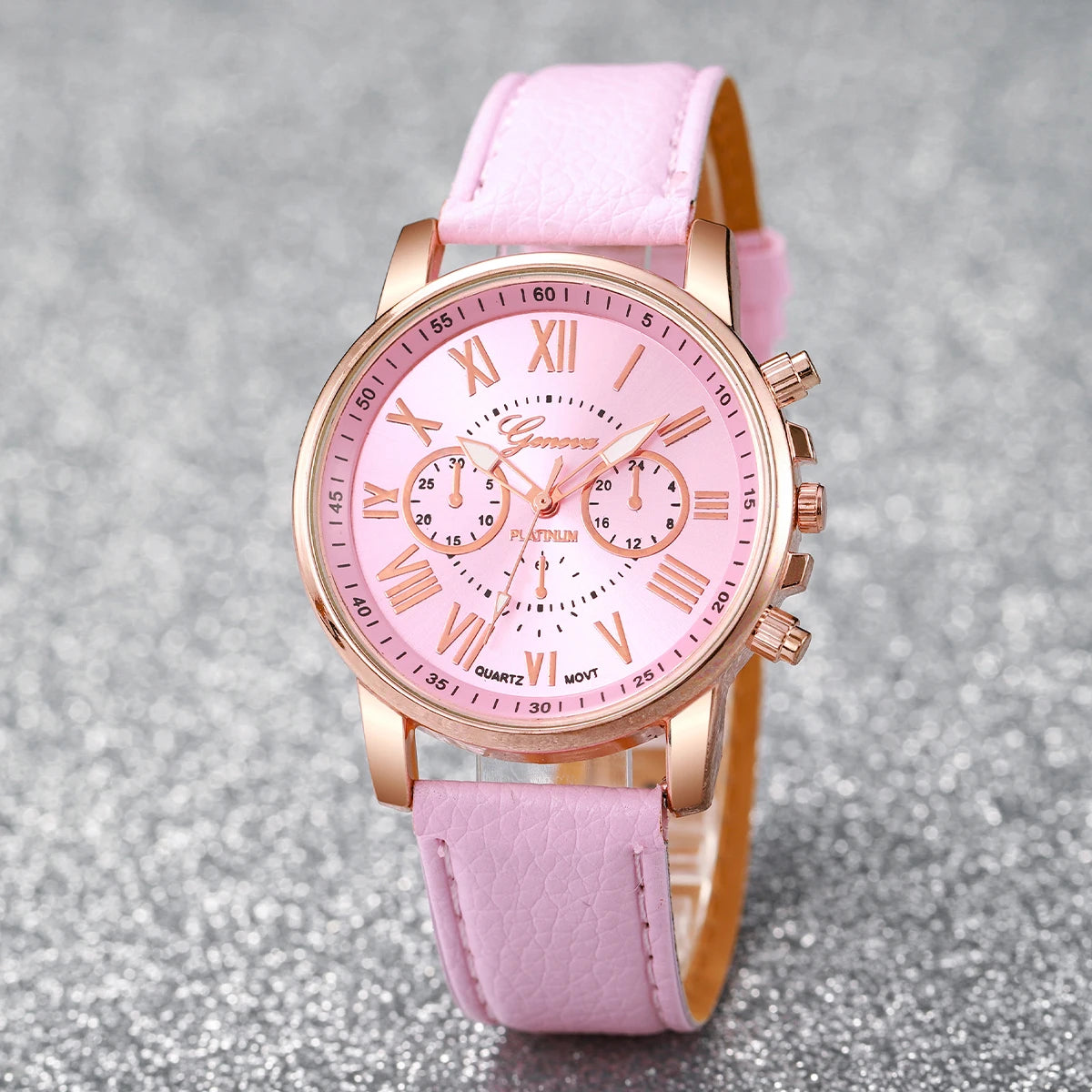 A pink fashion quartz wristwatch with a gold-toned case and a matching pink leather strap.
