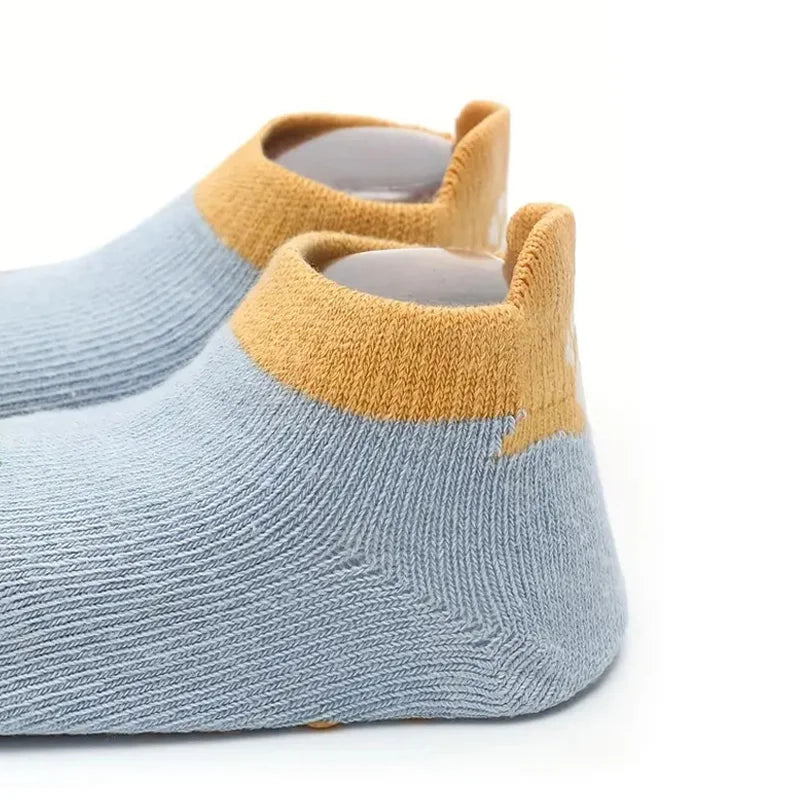 Hellblaue Stricksocken mit senffarbener Borte und Cartoon-Tiermuster