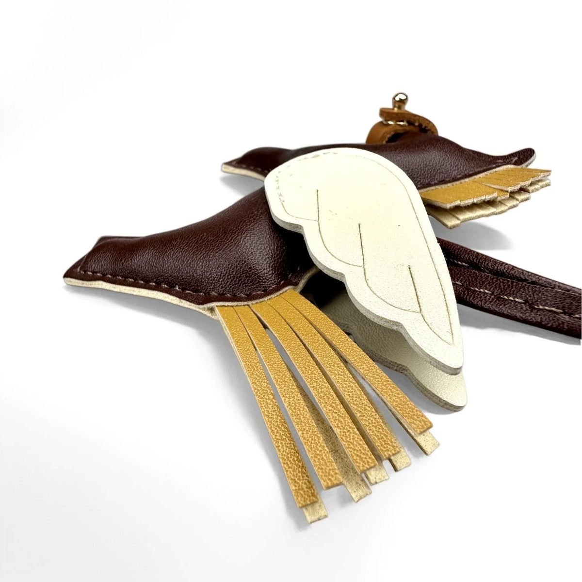 A brown leather winged pony keychain with gold fringe details.