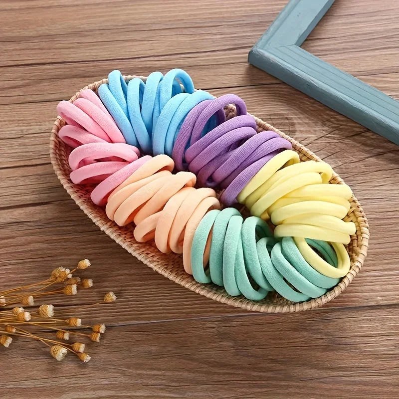 A colorful display of boho seamless elastic hair ties in various shades of pink, blue, purple, and yellow arranged on a woven