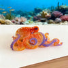 Pinces à cheveux en forme d'octopus colorées avec des tourbillons orange et violet