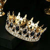 Couronne diadème en strass de cristal or posée sur une surface noire.