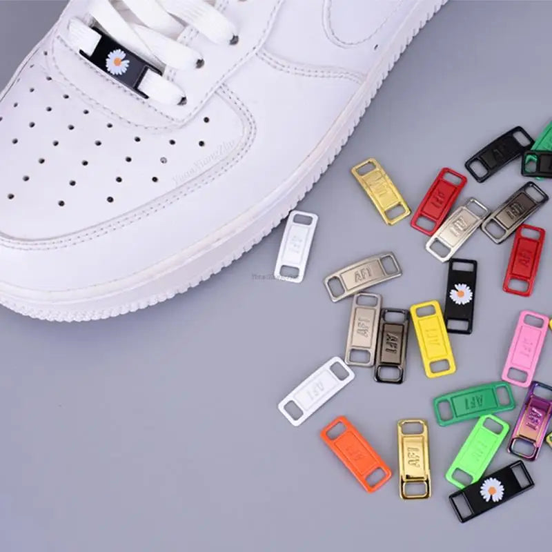 A close-up view of a white shoe with multiple metal and plastic charms attached to the laces.