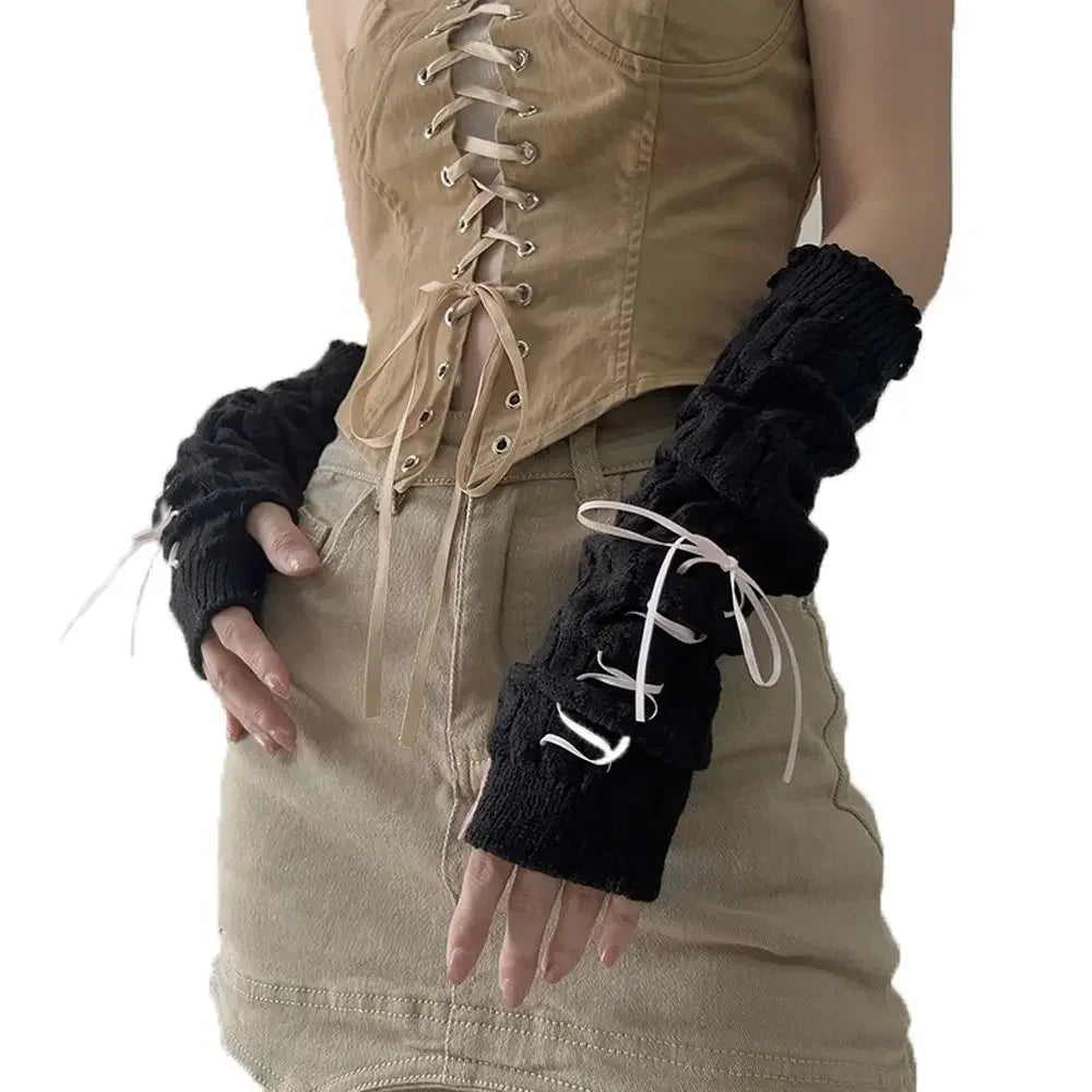 A person wearing fingerless arm warmers on their hands and a tan shirt.