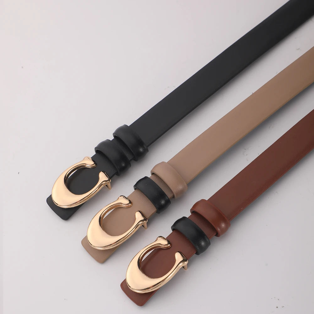 A close-up of a women's smooth double-sided belt with a C-shaped gold buckle shown in various leather colors.