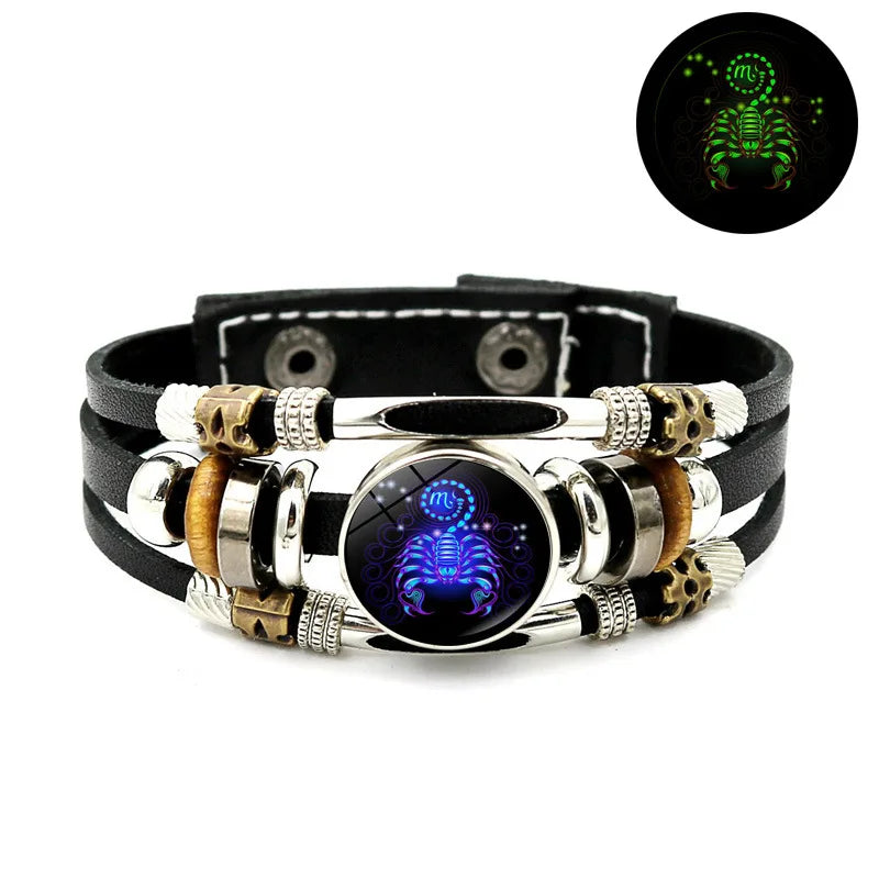 Schwarzes Lederarmband mit silbernen Perlen, goldenen Akzenten und einem zentralen leuchtend blauen Design.