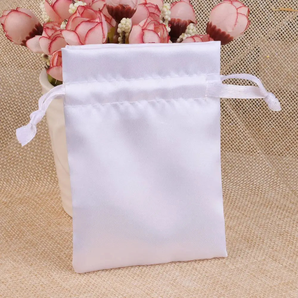 White satin drawstring pouch with pink roses and green accents