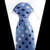 Blue silk necktie with white polka dots and silver accents, tied in a knot.