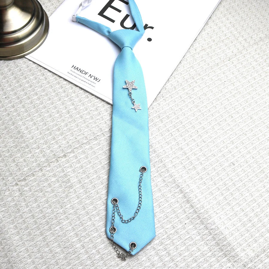 A light blue tie with a silver chain star decoration lying on a white paper.
