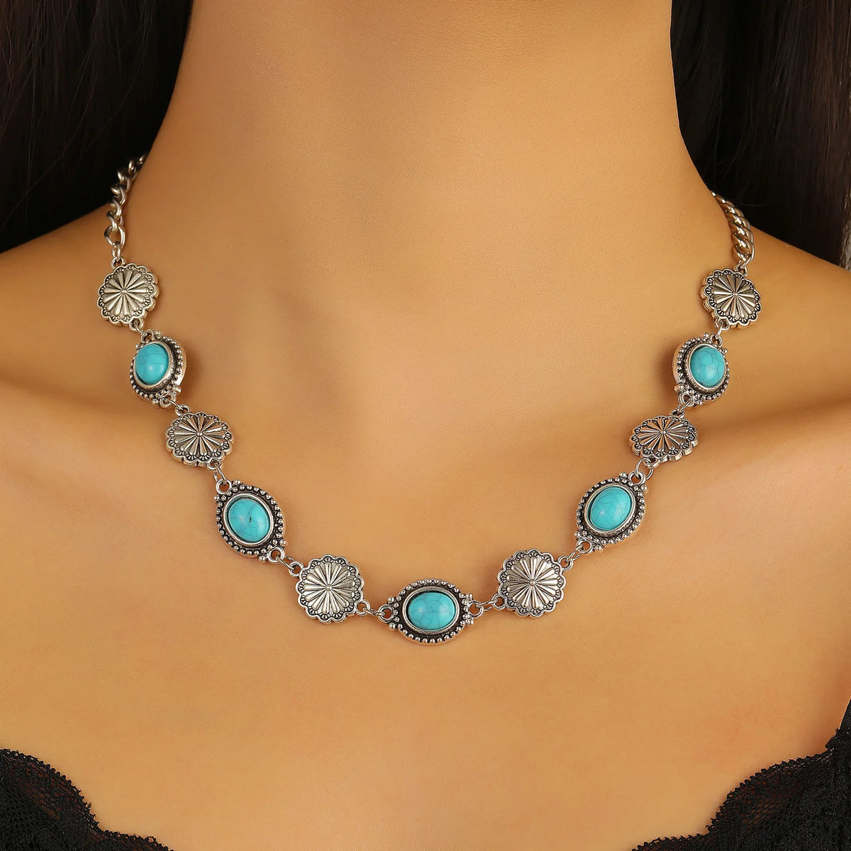 Silver and turquoise beaded necklace set featuring flower motifs worn around a woman's neck