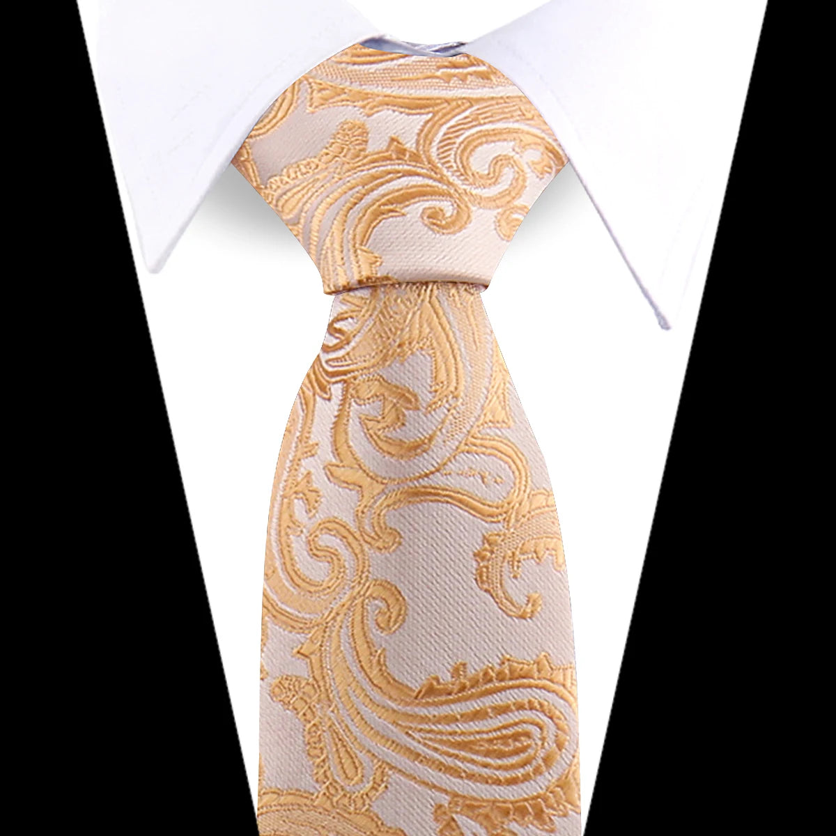 A close-up of an elegant men's floral paisley silk necktie in beige with gold embroidery, shown against a white shirt.