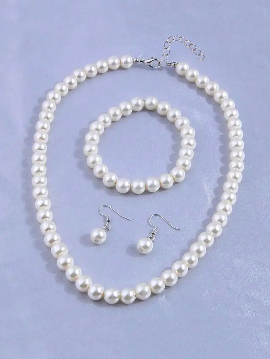 A set of four faux pearl jewelry pieces including a necklace and earrings displayed on a light blue background.