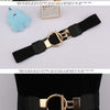 A black adjustable fashion belt with a gold buckle is displayed on a white background.
