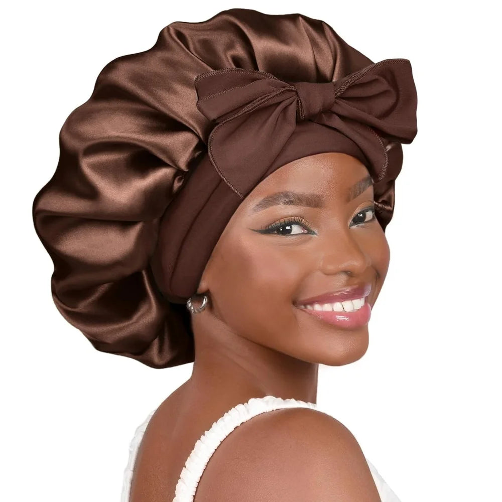 A woman models a satin brown sleeping bonnet with an adjustable tie band.
