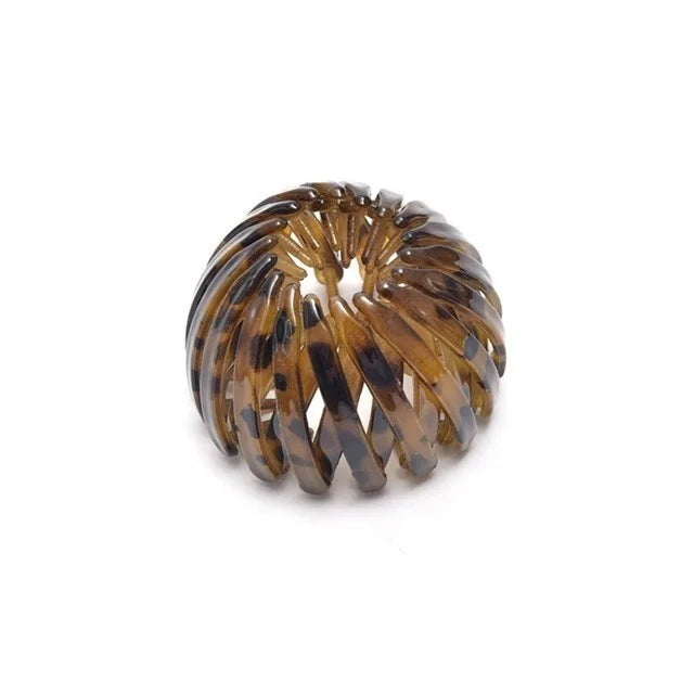 A close-up of elegant brown horsetail hair clips arranged in a spiral pattern.