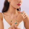 A close-up shot of a woman wearing a gold necklace and bracelet set featuring enamel plum blossoms.