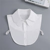 White fashion blouse with a false collar and detachable neckline shown flat lay.