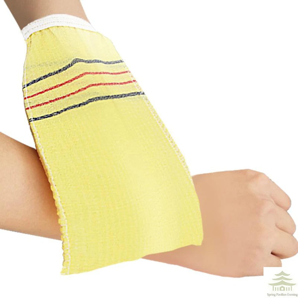 Yellow exfoliating bath washcloth with striped accents on a person's arm.