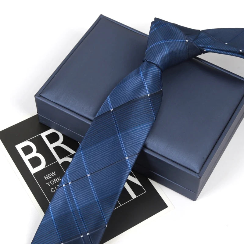 A dark blue striped skinny necktie is displayed on a black box.