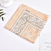A beige cotton bandana featuring a black bohemian print design with paisley and floral elements.