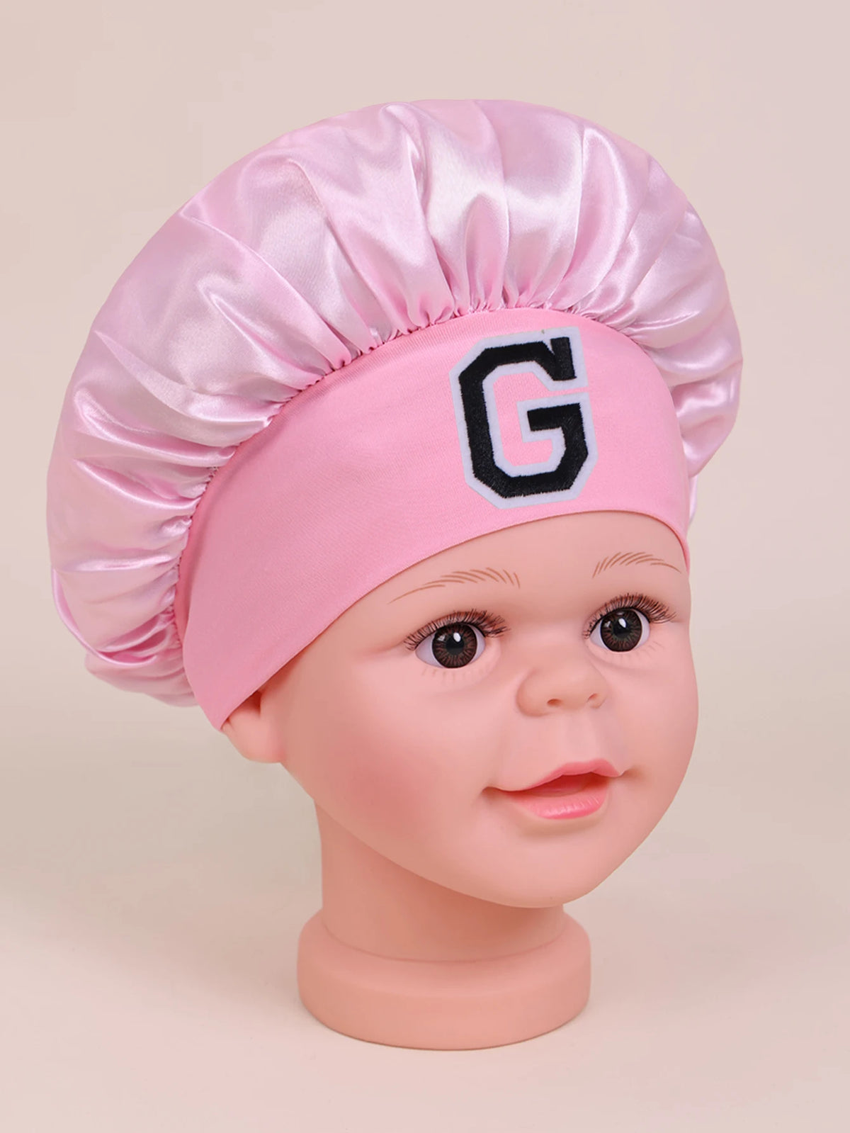 Pink sleep cap for kids with a satin top and a letter G detail